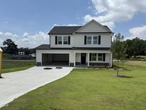 New two-story home with black and white exterior, an open garage, and a long, freshly poured concrete driveway at 10 Silver Ct, Smithfield, NC 27577