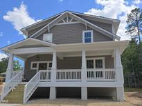 Two-story home featuring a covered front porch with white columns and railings, complemented by gray siding and a gabled roofline at 1005 Forrestal Pl, Durham, NC 27707
