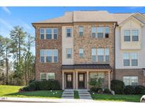 Two-story townhome featuring a brick facade, covered entrance, and well-maintained landscaping at 103 Ballyliffen Ln, Cary, NC 27519