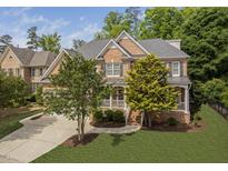 Charming two-story brick home with manicured lawn, mature trees, and inviting front porch at 107 Oxford Creek Rd, Cary, NC 27519