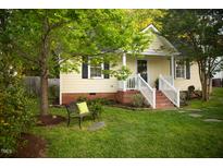 Charming home featuring a cozy front yard with a bench, green lawn, and tasteful landscaping at 112 E Edgewood Dr, Durham, NC 27704