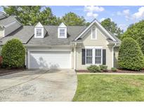 Charming home featuring a two-car garage, dormer windows, and manicured landscaping at 115 White Lake Ct, Cary, NC 27519