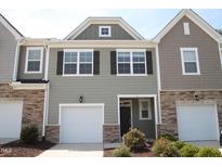 Charming townhome with a one-car garage, stone accents, and attractive curb appeal at 123 Hunston Dr, Holly Springs, NC 27540