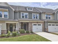 Charming townhome showcasing a stone facade, attached garage, and inviting curb appeal with manicured lawn at 1238 Exchange Pl, Durham, NC 27713