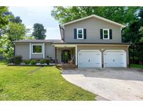 Charming two-story home featuring neutral siding, black shutters, a two-car garage, and well-maintained landscaping at 1321 Bloomingdale Dr, Cary, NC 27511