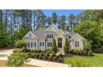 Stunning stone and gray two-story home with professionally landscaped front yard and manicured lawn at 14013 Wallberman Dr, Wake Forest, NC 27587