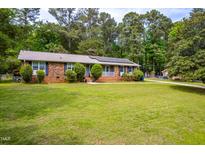 Charming one-story brick home with a well-manicured lawn and mature trees in a quiet neighborhood at 149 Baldwin Dr, Durham, NC 27712