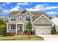 Charming two-story home featuring a manicured lawn, stone accents, and a two-car garage at 1811 Sandoval Dr, Durham, NC 27703