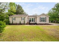 Charming single story home featuring manicured lawn, flower garden, and neutral exterior at 2005 Chalybeate Springs Rd, Fuquay Varina, NC 27526