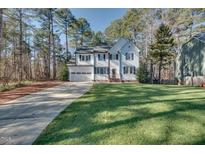 Charming two-story home featuring a well-maintained lawn, attached garage, and traditional architectural details at 215 Graduate Ct, Durham, NC 27713