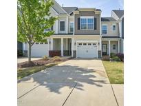 Charming townhome featuring a one-car garage and a well-maintained lawn and shrubbery at 225 Gulley Glen Dr, Garner, NC 27529