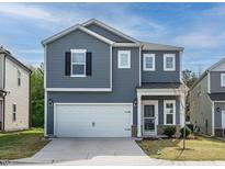 Charming two-story home with gray siding, a white garage door, and a well-manicured front yard at 253 Sweet Olive St, Clayton, NC 27527