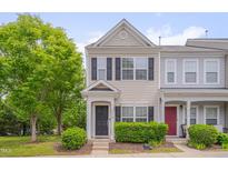 Charming two-story townhouse with black shutters, landscaped yard and lush green tree in front at 3114 Courtney Creek Blvd, Durham, NC 27713