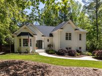 Charming white brick home featuring lush landscaping and a welcoming walkway at 3332 Langston Cir, Apex, NC 27539