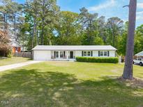 Charming one-story home with a well-manicured lawn, attached garage, and mature trees at 4908 Vallery Pl, Raleigh, NC 27604