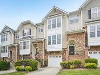 Charming townhouse with a stone facade, inviting entrance, and attached garage at 5026 Celtic Ct, Raleigh, NC 27612