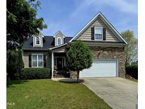 Charming two-story home featuring stone accents, a manicured lawn, and an attached two car garage at 503 Bellefont Ct, Knightdale, NC 27545