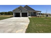 Charming single-story home features a two-car garage and a welcoming front porch at 56 Ruskin Dr, Smithfield, NC 27577