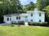 Charming two-story home with a bright teal door and a freshly manicured front lawn at 5817 Wintergreen Dr, Raleigh, NC 27609