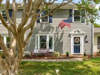 Charming home featuring a patriotic display with an American flag and blue shutters enhancing the curb appeal at 6718 Twin Tree Ct, Raleigh, NC 27613