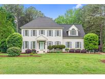 Charming two-story home with a beautifully landscaped front yard and a light blue front door at 7321 Clarincarde Ct, Wake Forest, NC 27587