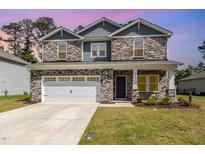 Two-story home with stone and gray siding and a two-car garage, providing an attractive curb appeal at 8013 Toddwick Ct, Raleigh, NC 27616