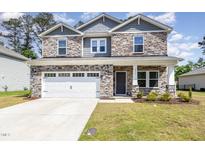 Charming two-story home with stone accents, a paved driveway, and a two-car garage at 8013 Toddwick Ct, Raleigh, NC 27616