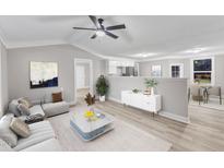 Bright open-concept living area featuring modern furnishings, hardwood flooring and neutral color palette at 8201 Rhodes Rd, Apex, NC 27539
