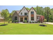 Stunning home featuring a manicured lawn, stone accents, and a welcoming front entrance at 1108 Delilia Ln, Wake Forest, NC 27587