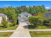 Charming two-story home featuring a well-maintained lawn and a long driveway leading to a two-car garage at 1198 Shining Water Ln, Creedmoor, NC 27522