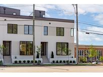Modern white brick home with black framed windows and manicured landscaping at 1303 Chamblee Hill Ct, Raleigh, NC 27608