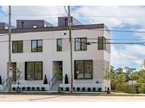 Modern, three-story townhouse with stylish white brick and contemporary black framed windows at 1308 Chamblee Hill Ct, Raleigh, NC 27608