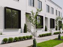 Newly constructed townhomes showcasing white brick facade, dark framed windows and manicured landscaping at 1308 Chamblee Hill Ct, Raleigh, NC 27608