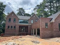 New construction, two-story home with brick exterior and an attached three car garage at 1500 Ridge Rd, Raleigh, NC 27607