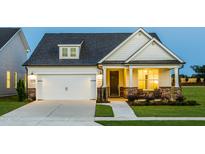 Charming two-story home with a well-maintained lawn, covered porch, and attached garage at 1606 Garden Park Cir, Fuquay Varina, NC 27526