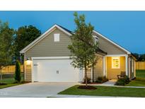Charming home featuring a two-car garage, covered entryway and professionally landscaped front yard at 1630 Garden Park Cir, Fuquay Varina, NC 27526