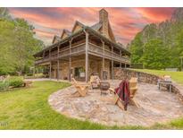 Charming stone home featuring a spacious patio with an outdoor fireplace and ample seating at 169 Country Brooke Lane Ln, Roxboro, NC 27574