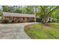 Charming red brick home featuring a well-manicured lawn and a curved driveway leading to the front entrance at 213 Old Mallard Rd, Smithfield, NC 27577