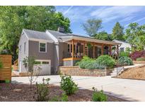 Charming home featuring a welcoming front porch, an attached garage, and a well-maintained, landscaped front yard at 2811 Van Dyke Ave, Raleigh, NC 27607
