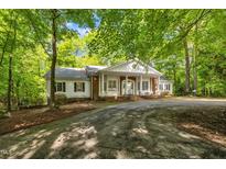 Charming brick and white home nestled among trees with a circular driveway at 2901 Horse Shoe Farm Rd, Wake Forest, NC 27587