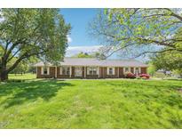 Ranch home with brick facade, covered porch and large front yard framed by mature trees at 3011 Old Hillsborough Rd, Mebane, NC 27302