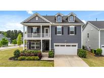 Charming two-story home featuring stone accents, a balcony, and a two-car garage at 316 Barley Mill Rd, Holly Springs, NC 27540