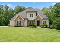 Charming home featuring stone accents, a manicured lawn, and lush landscaping at 325 Forest Bridge Rd, Youngsville, NC 27596