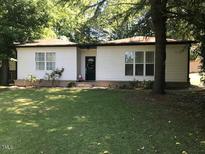 Charming single-story home with a well-maintained lawn and mature trees offers great curb appeal at 5002 Wickham Rd, Raleigh, NC 27606