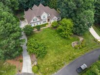 Stunning aerial view of an expansive home with a lush green lawn, mature trees, and manicured landscaping at 7212 Donneeford Rd, Wake Forest, NC 27587