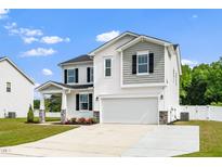 Two-story home features a two-car garage, white siding and black shutters and a manicured lawn at 73 Windswept Way, Fuquay Varina, NC 27526