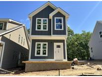 New two-story home featuring gray siding, white trim and large windows on a bright, sunny day at 903 Linwood Ave, Durham, NC 27701