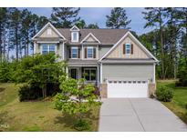 Charming two-story home with a manicured lawn, two-car garage and inviting front porch nestled among mature trees at 948 Uprock Dr, Cary, NC 27519