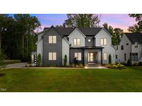 Striking two-story home featuring a modern design, manicured lawn, and stylish landscaping at 949 Harrison Ridge Rd, Wake Forest, NC 27587
