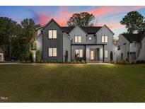 Striking two-story home featuring a modern exterior with gray siding, manicured lawn, and professional landscaping at 949 Harrison Ridge Rd, Wake Forest, NC 27587
